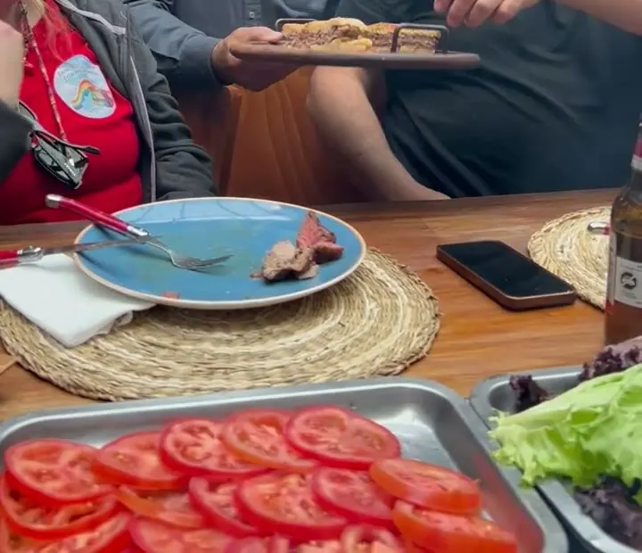Invitados sirviéndose carne en la mesa