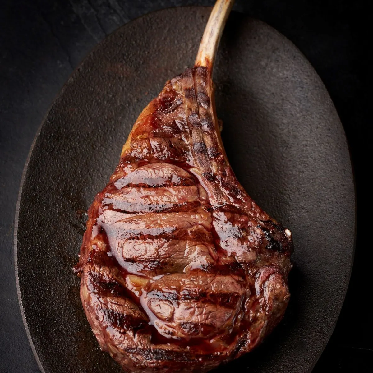 Tomahawk crudo sobre tabla con cuchilla